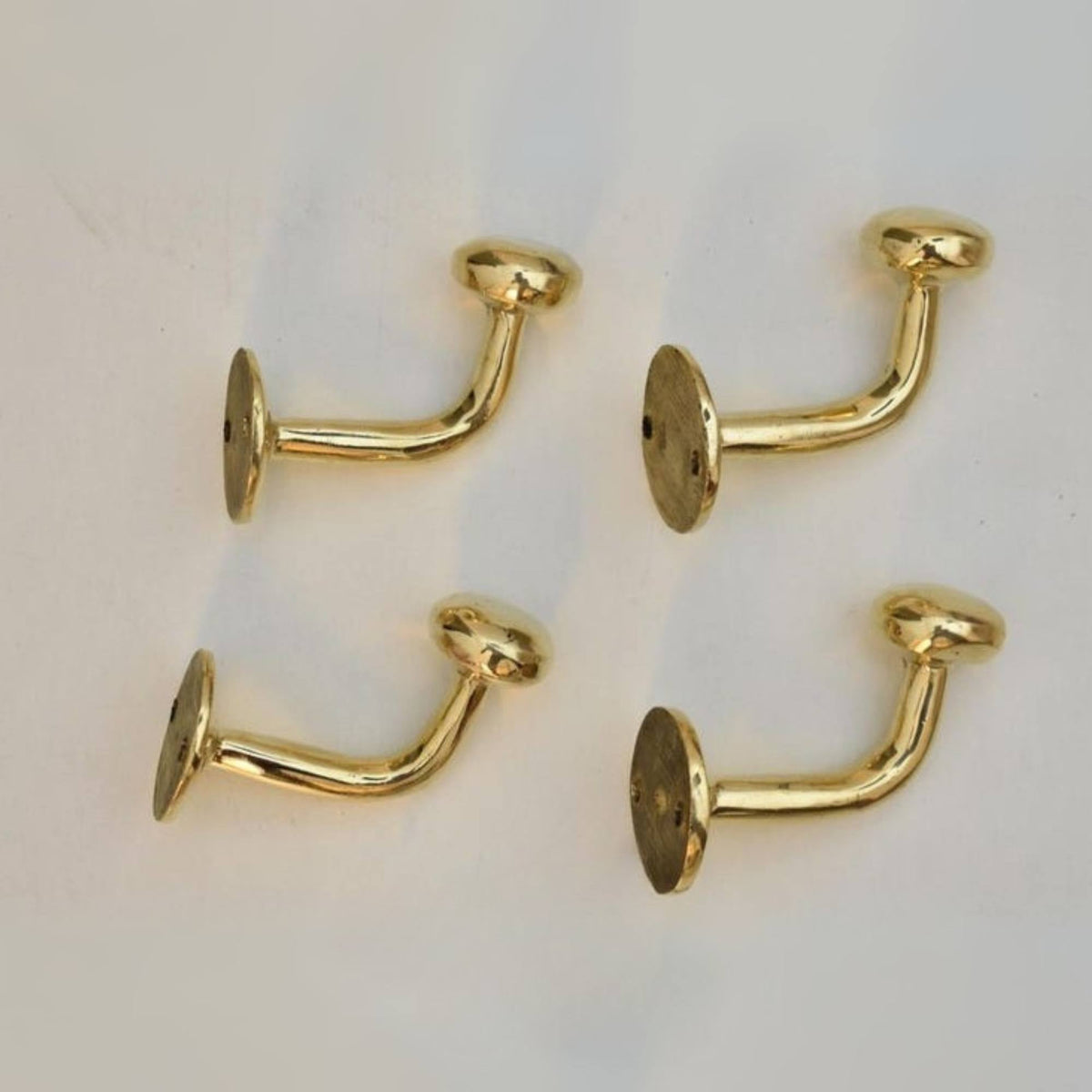 Four gold earrings on a light background